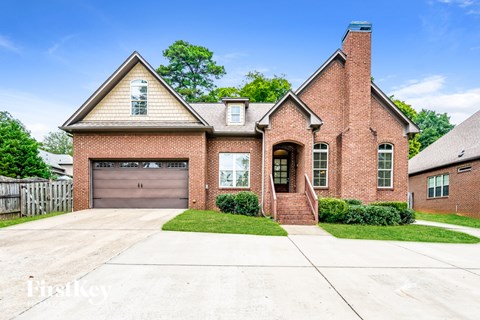A brick house with a garage door and a chimney.