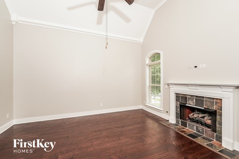 A room with a fireplace and a fan on the ceiling.