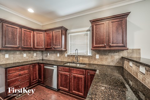 A kitchen with wooden cabinets and a granite countertop.