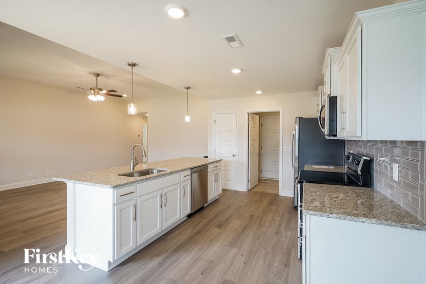 a kitchen with white cabinets and a counter top and a sink