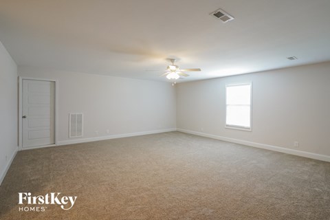 a bedroom with white walls and a ceiling fan