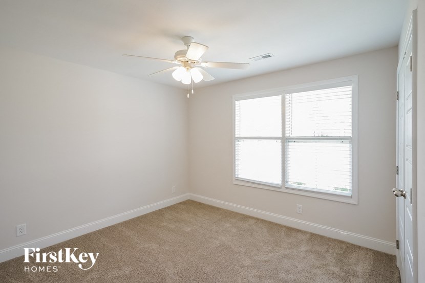 a bedroom with a ceiling fan and a window