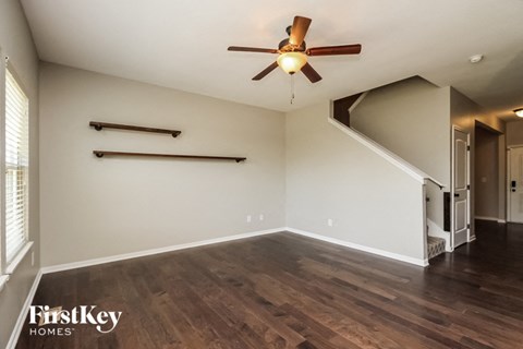 the upstairs living room with wood flooring and a ceiling fan