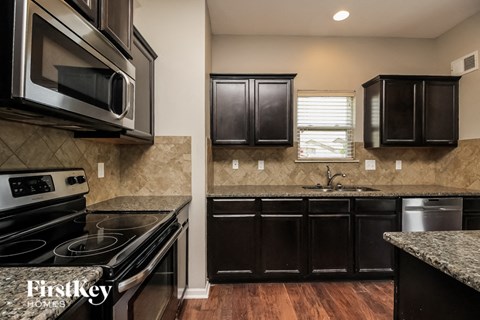 a kitchen with black cabinets and stainless steel appliances
