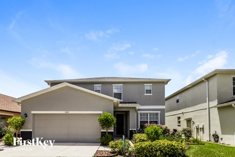 A house with a garage and a driveway in front of it.