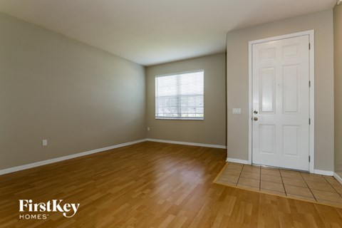 A room with wooden flooring and a white door.