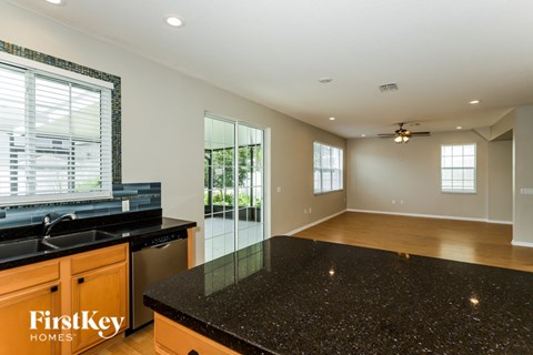 A kitchen with a black granite countertop and wooden cabinets.