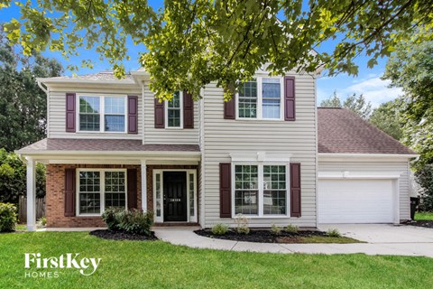 a white house with purple shutters and a driveway