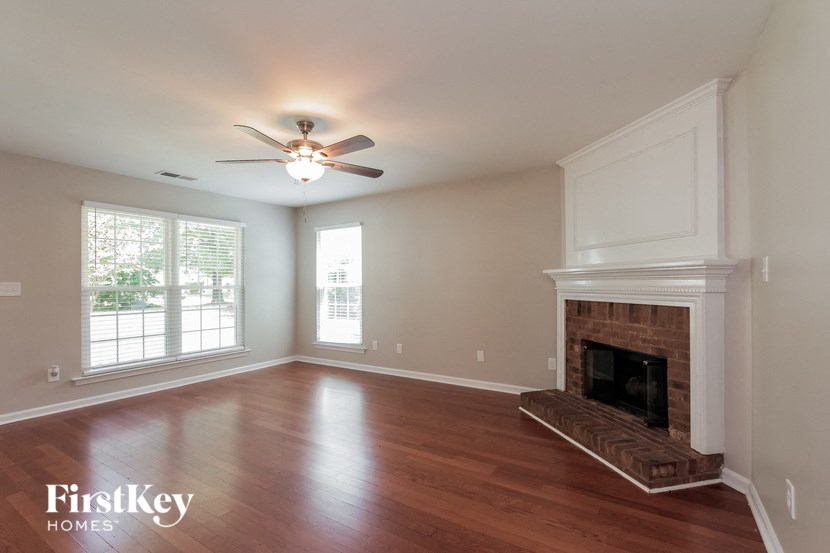 a living room with a fireplace and a ceiling fan