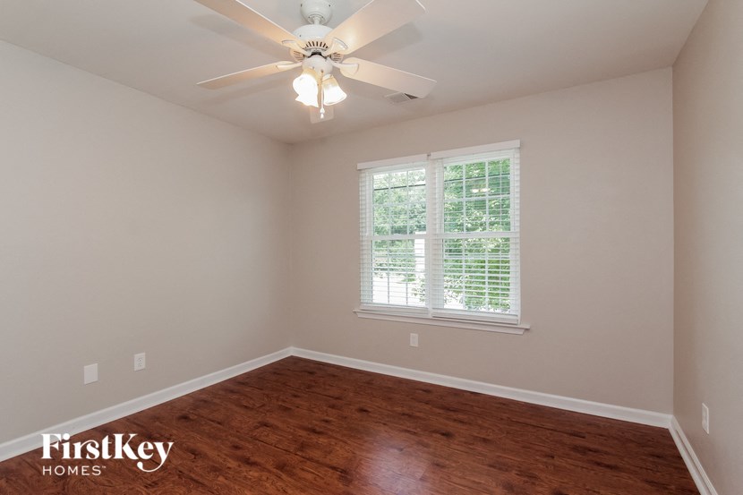 a empty room with a ceiling fan and a window