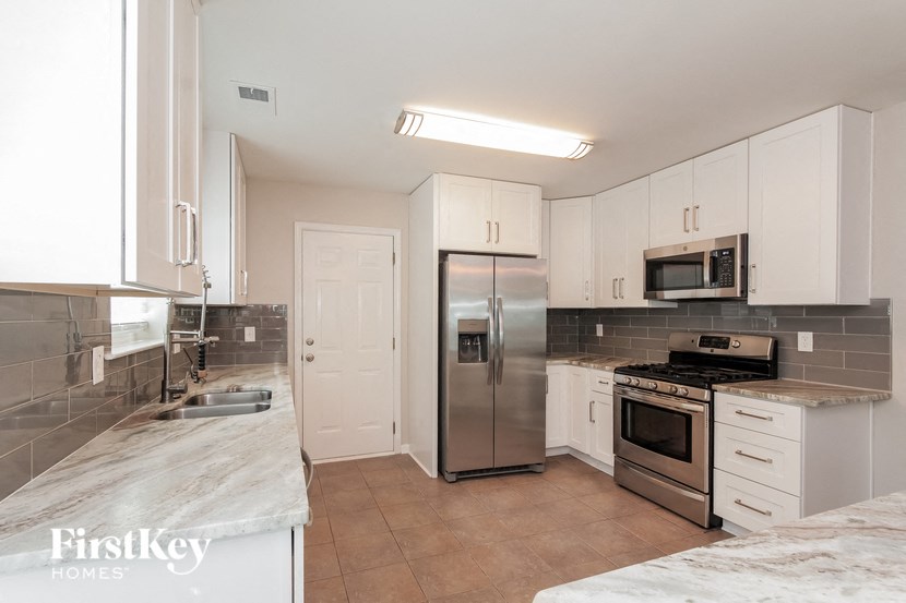 a kitchen with stainless steel appliances and white cabinets