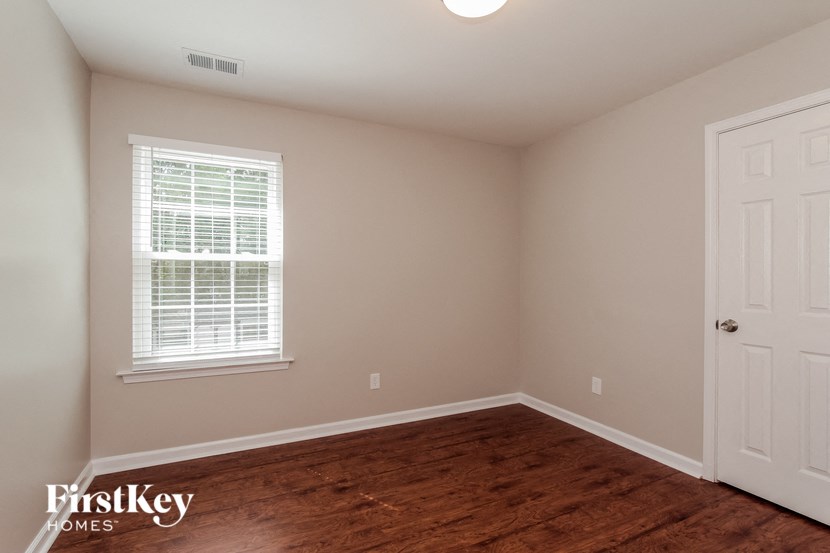 the bedroom of a home with a hard wood floor and a white door