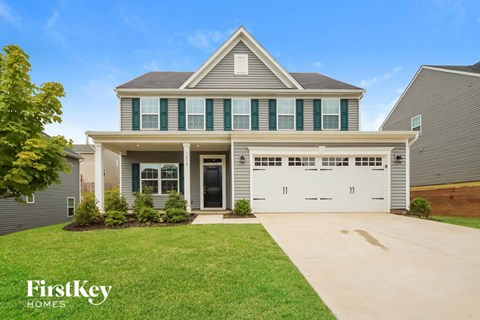 A house with a garage and a driveway in front of it.
