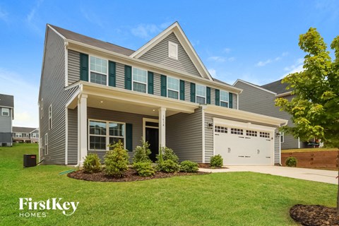 A modern house with a grey exterior and a white garage door.