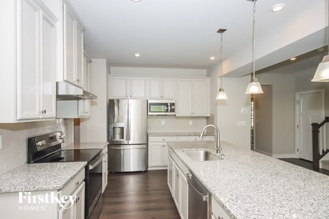 A modern kitchen with granite countertops and stainless steel appliances.