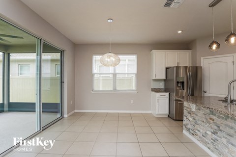 A kitchen with a stone counter and a dishwasher.