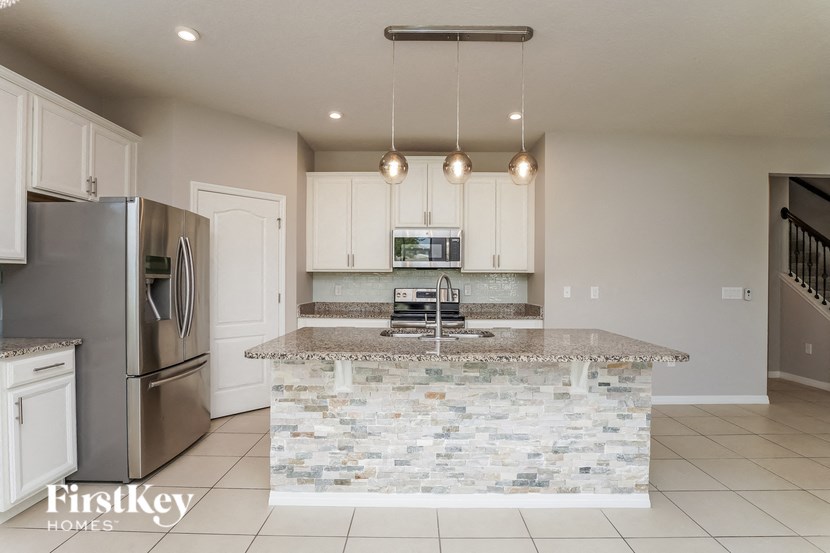 A kitchen with a marble island and stainless steel appliances.