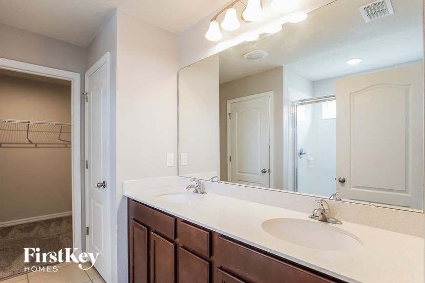 A bathroom with a white sink and a mirror.