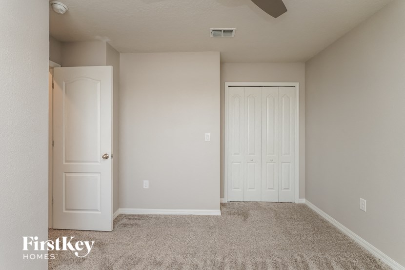 A room with a carpeted floor and two doors.
