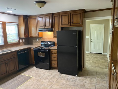 a kitchen with black appliances and wooden cabinets