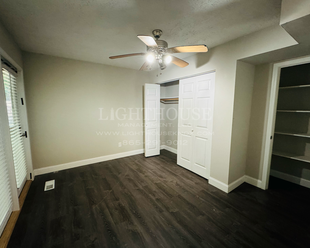 a bedroom with a closet and a ceiling fan