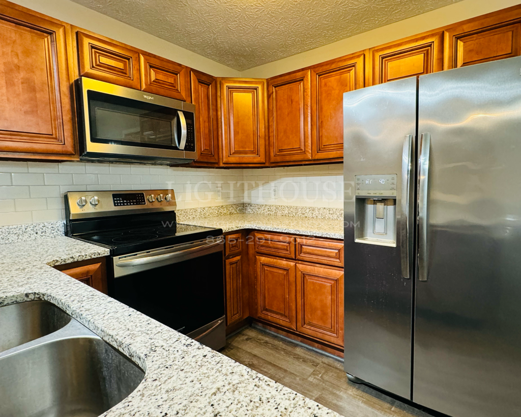 a kitchen with stainless steel appliances and wooden cabinets