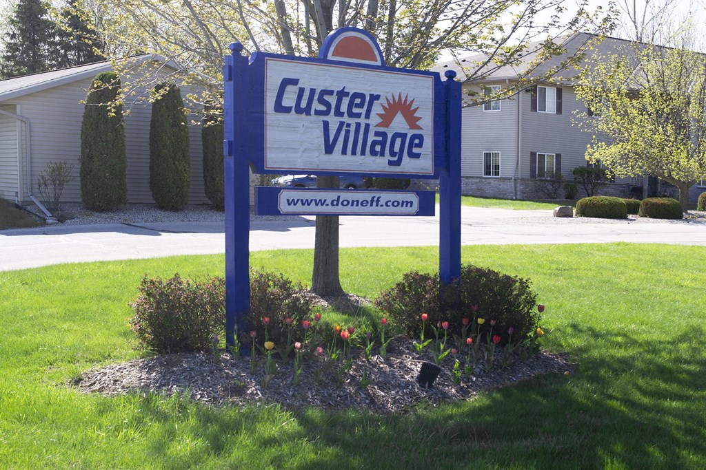 a sign for custard village in front of a house