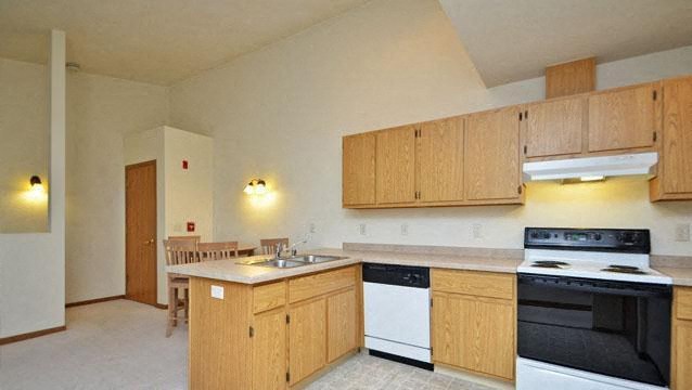 a kitchen with wooden cabinets and a stove and a sink