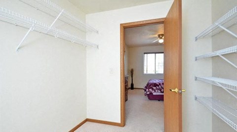 an empty closet in a bedroom with a bed