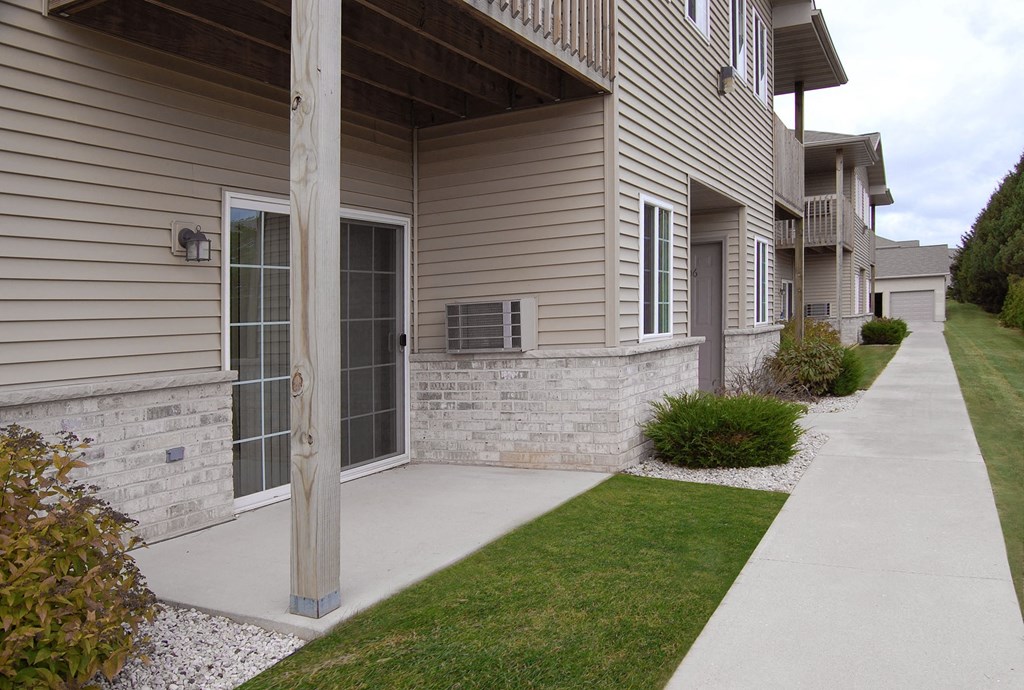 a walkway in front of a house with a garage door