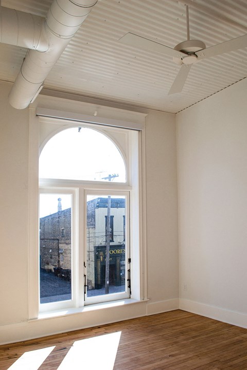 a living room with a large window and a wooden floor