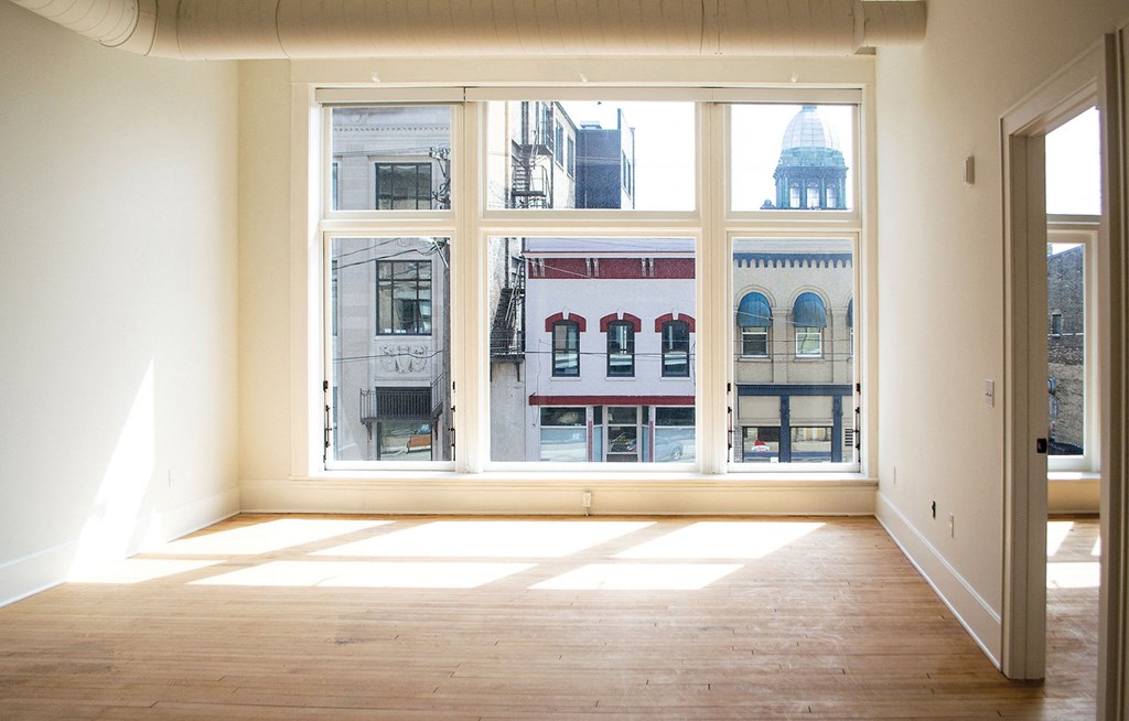a living room with a large window and a wooden floor