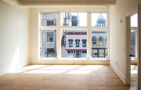 a living room with a large window and a wooden floor