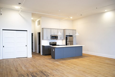 an open living room and kitchen with a wood floor and a blue counter top