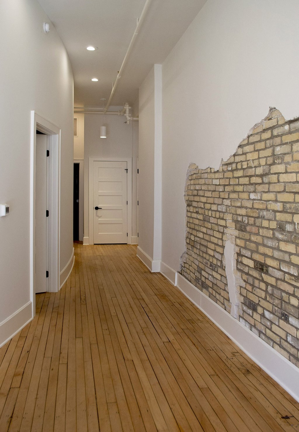 a living room with a exposed brick wall and wooden floors