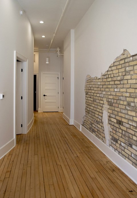 a living room with a exposed brick wall and wooden floors
