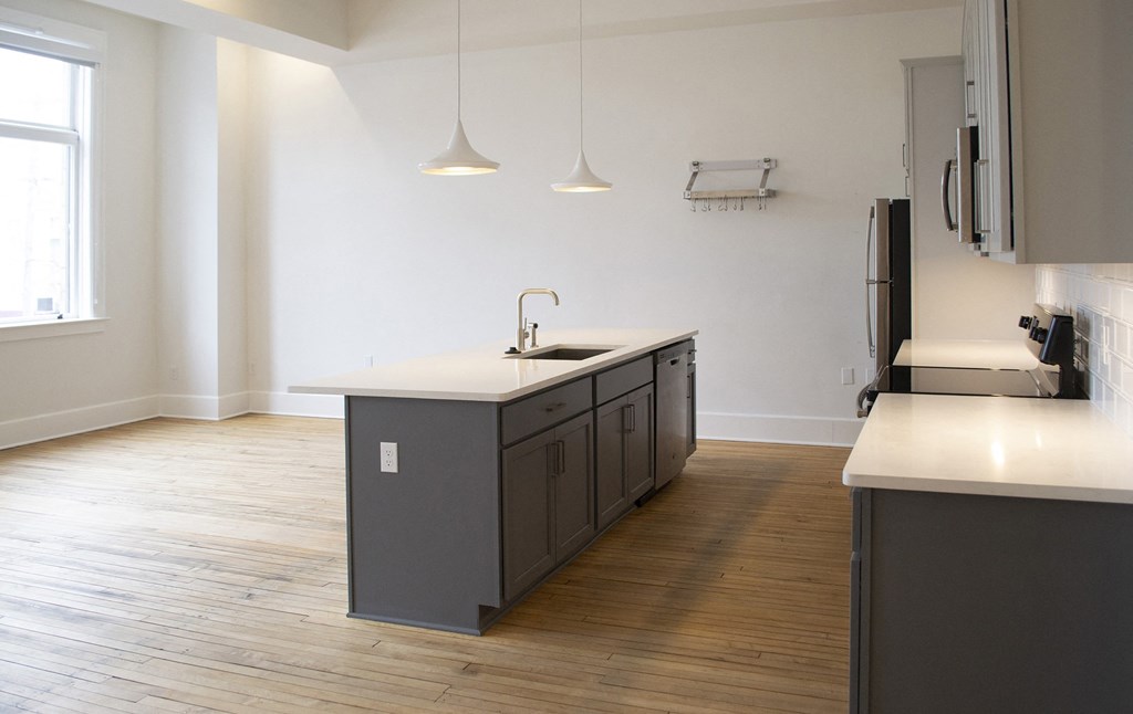 an empty kitchen with an island in the middle of it