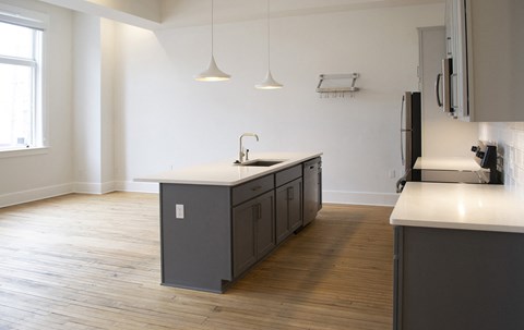 an empty kitchen with an island in the middle of it