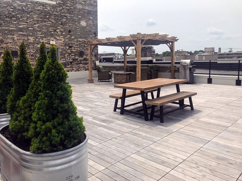 a picnic table on a roof terrace with a pergola