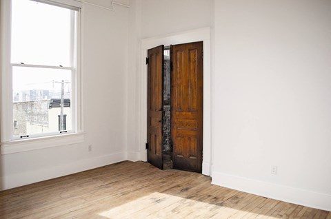 a room with a wooden floor and a wooden door