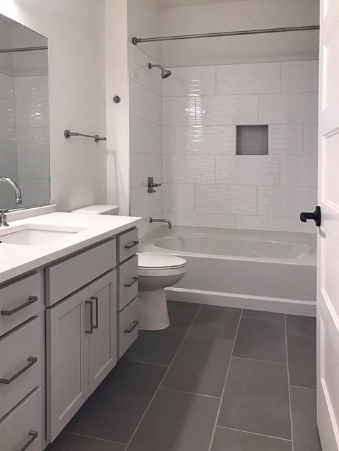 a bathroom with a toilet and a tub and a sink