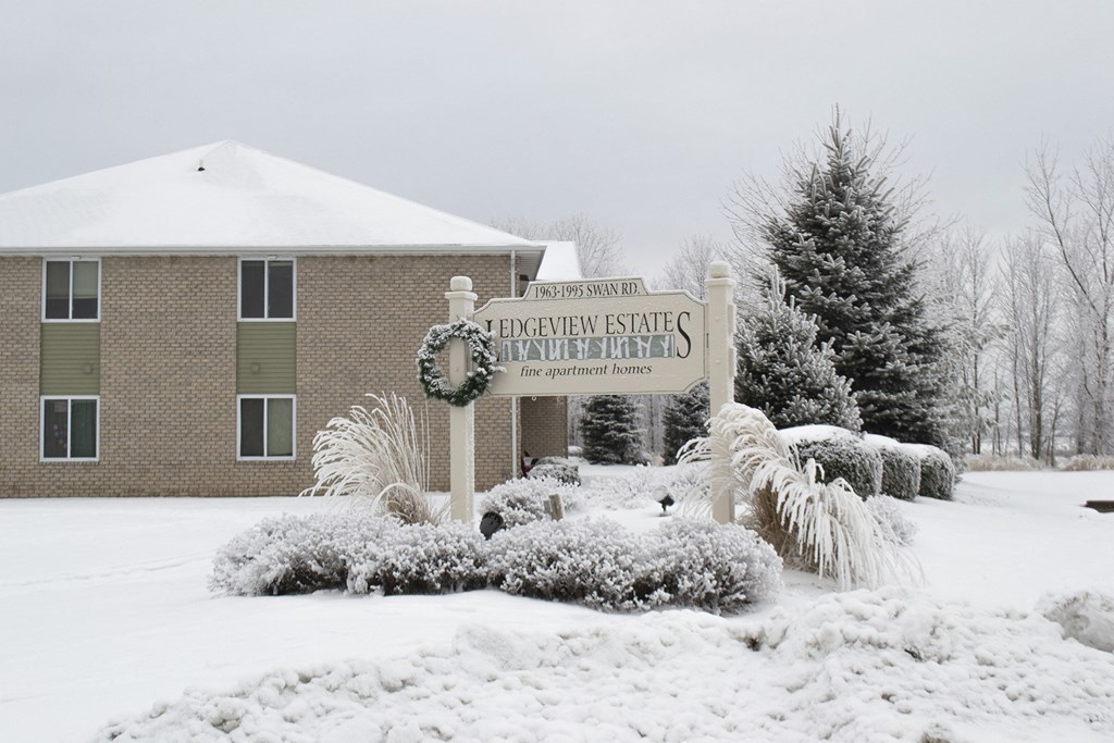 a sign in front of a building covered in snow