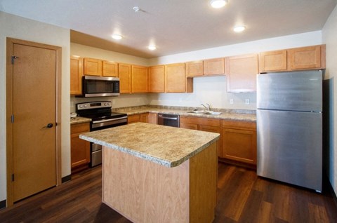 a kitchen with wooden cabinets and stainless steel appliances