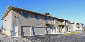 the front of an apartment building with garage doors