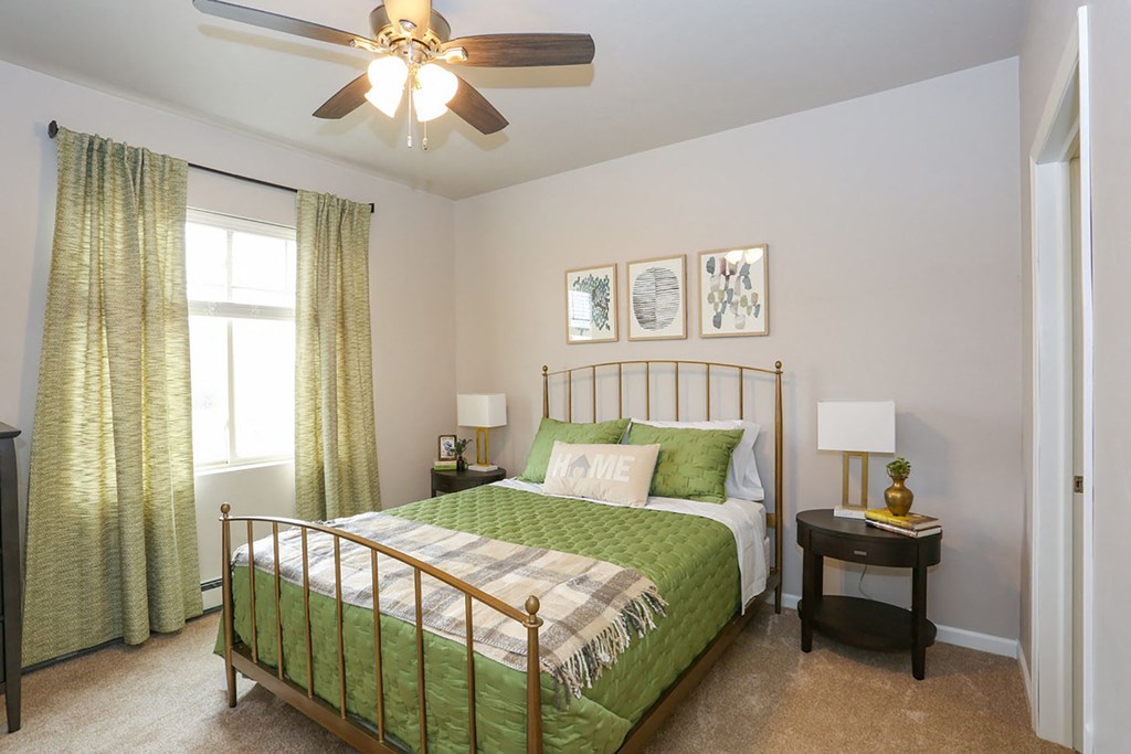a bedroom with a bed and a ceiling fan