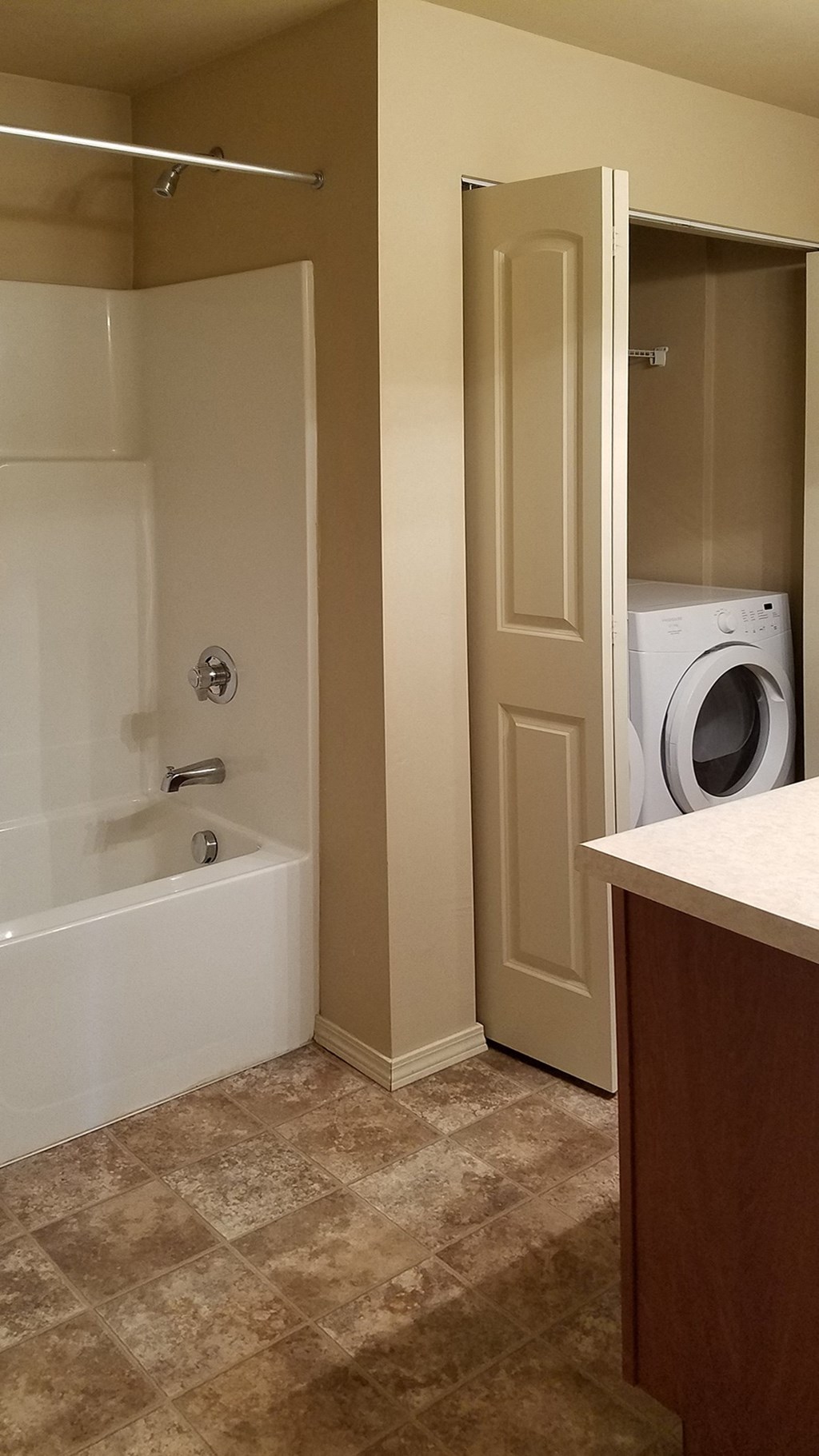a bathroom with a tub and a washing machine in it
