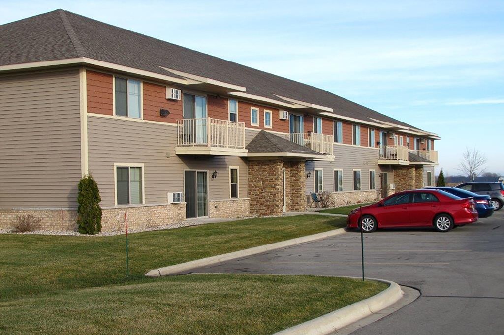 a red car parked in front of an apartment building