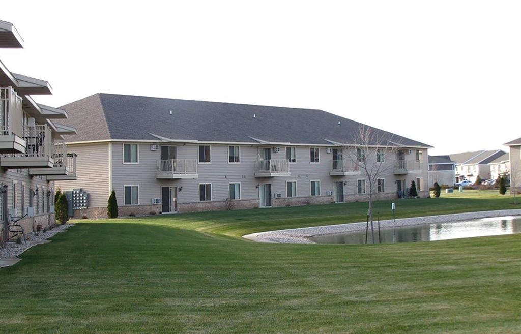 a large building with a pond in front of it