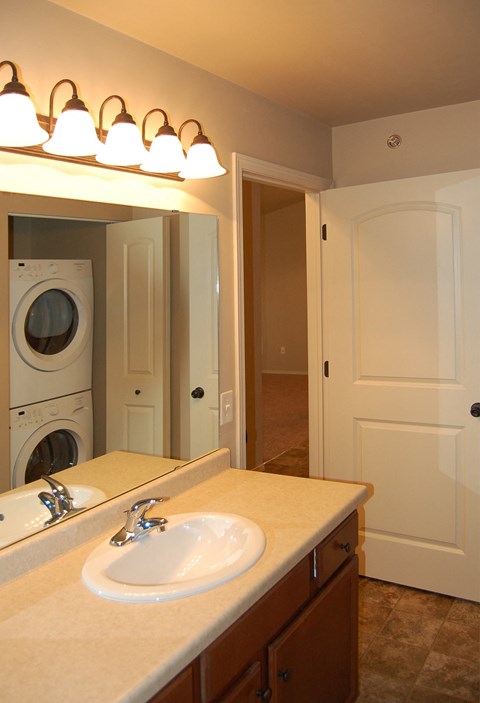 a bathroom with a sink and a washer and dryer in it