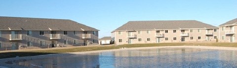 two houses are next to a pool of water